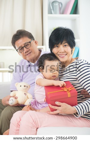 asian grand parents with grand daugther celebrating christmas