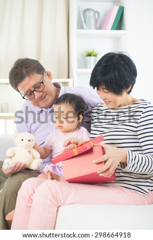 asian grand parents with grand daugther celebrating christmas