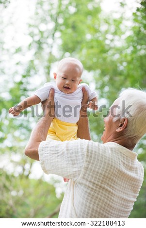 Asian Chinese grandpa and grandson having fun at outdoor garden.