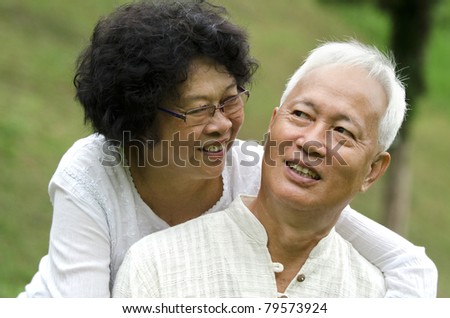 asian senior couple with green natural background