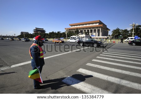 BEIJING, CHINA - APRIL 1:A traffic guard watches over the pedestrian crossing near to the Tiananmen Square, Beijing on April 1, 2013.
