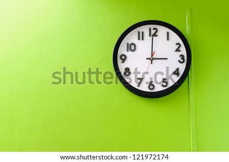 Clock showing 3 o\'clock pm on a green wall