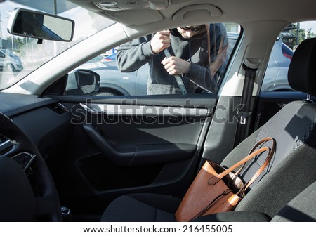 Thief breaking in a car