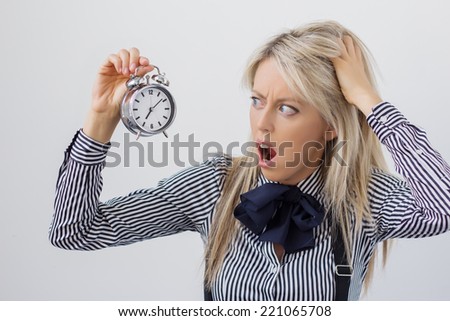 Stressed and frustrated woman holding alarm clock