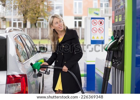 Woman refilling car with fuel