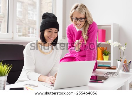 Two female colleagues working together in office