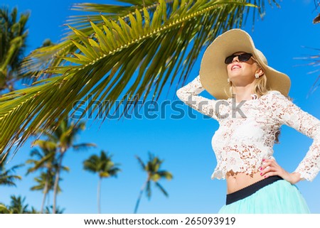 Young happy woman with palm trees in background