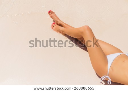 Beautiful woman\'s legs on the beach