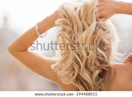 Blonde woman holding her hands in hair