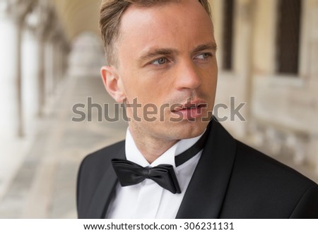 Portrait of confident sexy man in tuxedo and bow tie