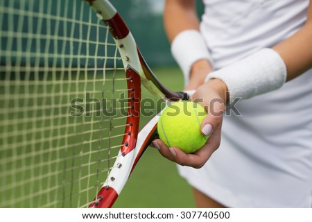 Tennis player holding racket and ball in hands