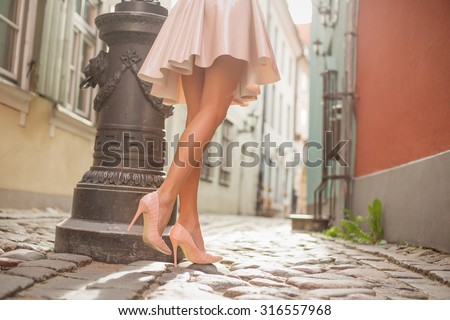 Sexy lady with beautiful legs walking in old town
