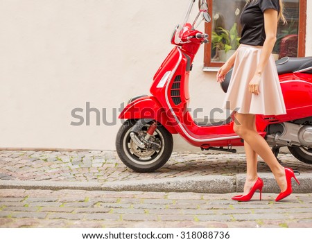 Lady in front of red moto scooter