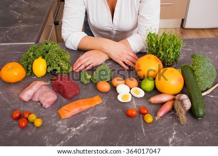 Woman in kitchen with different raw foods