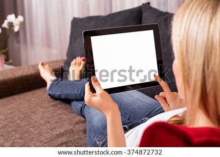 Woman sitting on couch and using tablet