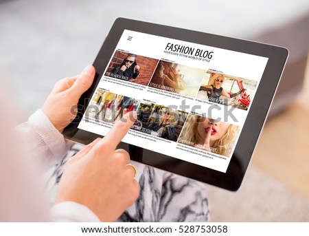 Woman reading fashion blog on tablet