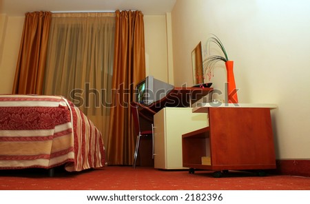 Luxury hotel room decor accommodation with TV set, bed, flowers bowls and ashtray