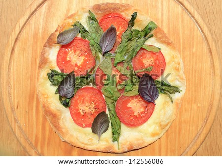 Pizza with mozzarella cheese , fresh tomato and spinach