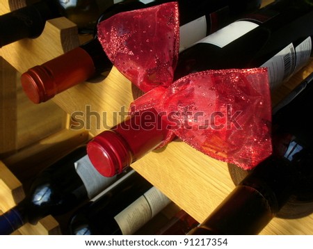 wine bottles with red ribbon stacked on wooden racks