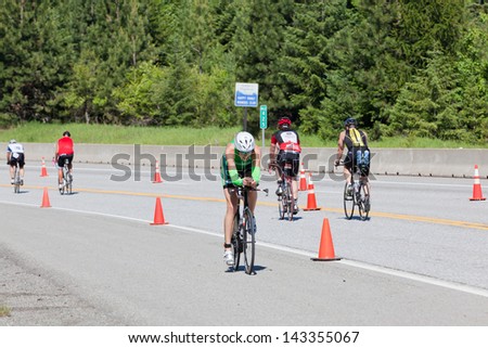 COEUR D ALENE, ID - JUNE 23: Heather Wurtele of Canada biking down hill at the June 23, 2013 Ironman Triathlon in Coeur d\'Alene, Idaho. Heather took first place in the woman\'s division with 9:16:02.
