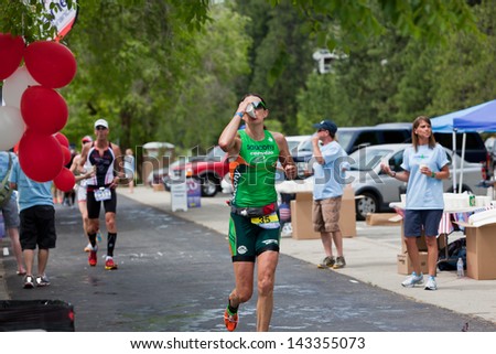 COEUR D ALENE, ID - JUNE 23: Heather Wurtele of Canada drinking water as she runs  at the June 23, 2013 Ironman Triathlon in Coeur d\'Alene, Idaho. Heather took first place in the woman\'s division.