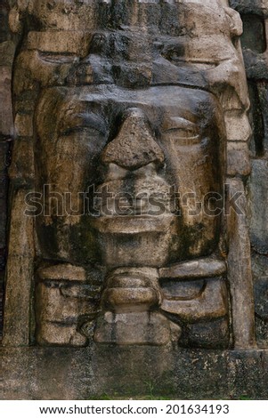 Close up of an Olmec style face that adorns the side of the Mask Temple at the Mayan site of Lamanai in Belize.