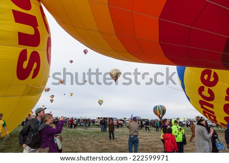 Albuquerque, NM, October 8:  Hot air balloons frame people taking pictures with balloons in flight in the background at the Balloon Fiesta in Albuquerque, New Mexico on October 8th, 2014.