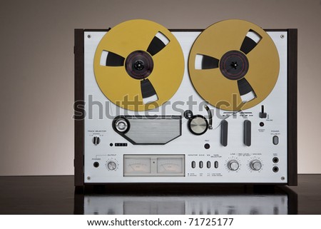 Vintage Reel-to-Reel stereo tape deck recorder closeup on the dark background