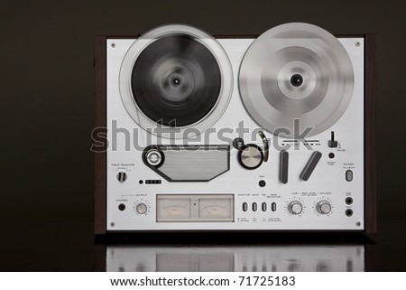 Vintage Reel-to-Reel stereo tape deck recorder closeup on the dark background