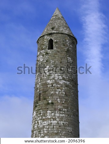 A tall round tower at the Rock of Cashel in Ireland set against a nice blue sky