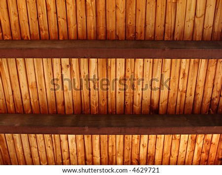 A richly colored wooden slat ceiling with exposed beams