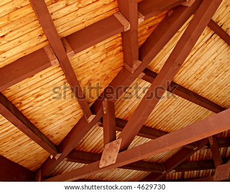A richly colored wooden slat ceiling with exposed beams
