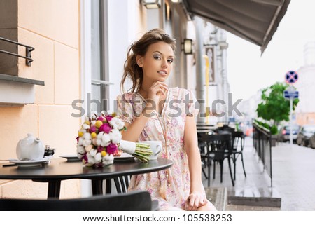 A pretty young woman in a cafe. Outdoors