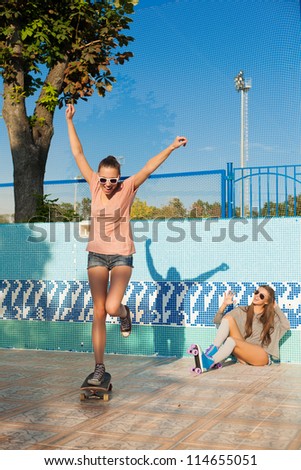 Two young active women skating in roller park, outdoors