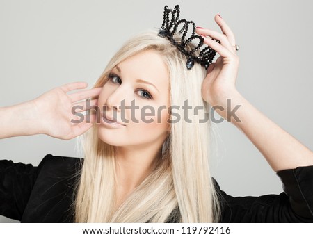 Closeup of a blonde woman with black crown, indoors