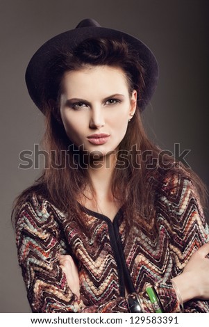 Woman with open lips in hat on dark background, indoor