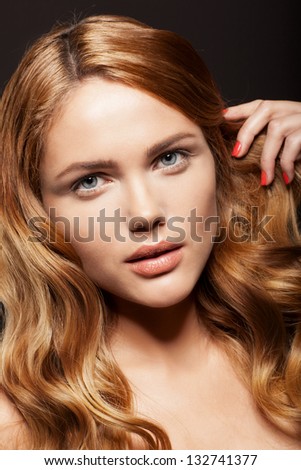 Beauty face of woman with clean skin and long hair on dark background