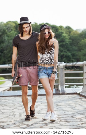 Couple Walk On The Bank Of A River. Young Active People. Outdoors, Lifestyle