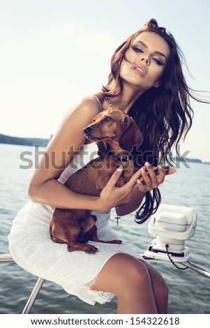 Happy Sexy Woman With Dog On The Luxury Boat In Open Sea In Summer. Caucasian Female Model. Outdoors, Lifestyle.
