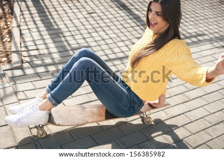 Beautiful young girl riding on a long-board in the afternoon. Skateboarding. Outdoors, lifestyle