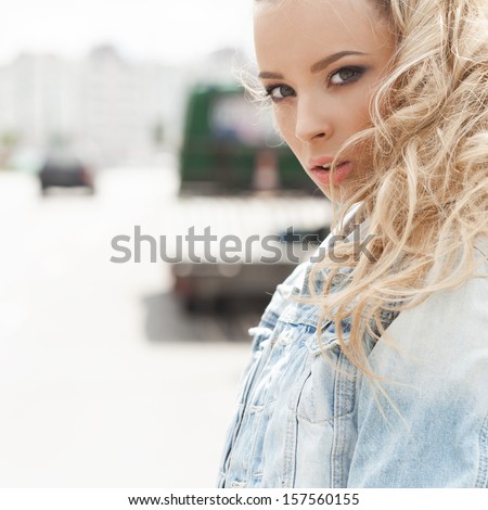 Young pretty woman standing in front of the sun. Urban street style. Outdoors, lifestyle.