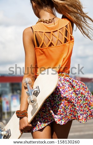 Sexual Woman With Skateboard Walking On Street. Urban Style. View From The Back. Outdoors, Lifestyle