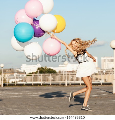Happy Young Woman Having Fun With Colorful Latex Balloons. Gorgeous Thick Wavy Hair. Outdoors, Lifestyle