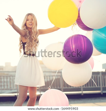 Sensual Young Woman Enjoying Witn Big Colorful Latex Balloons Against The Evening Sun Going Down. Pastel Colors. Outdoors, Lifestyle