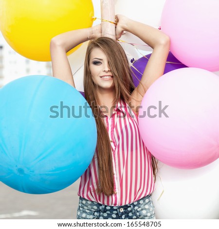 Happy young woman  with big colorful latex balloons. Outdoors, lifestyle