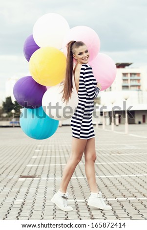 Happy young woman  with big colorful latex balloons. Outdoors, lifestyle