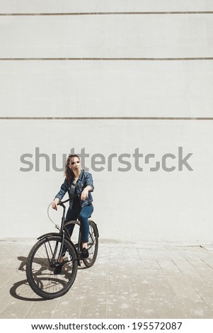 Girl hipster standing with black vintage bike. Outdoor lifestyle portrait