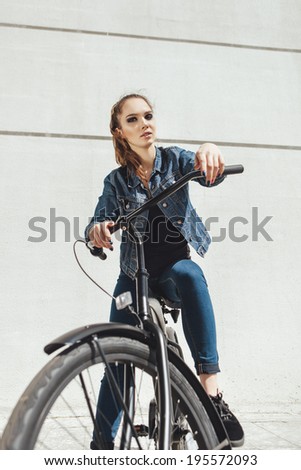 Pretty girl hipster standing with black bike. Outdoor lifestyle portrait