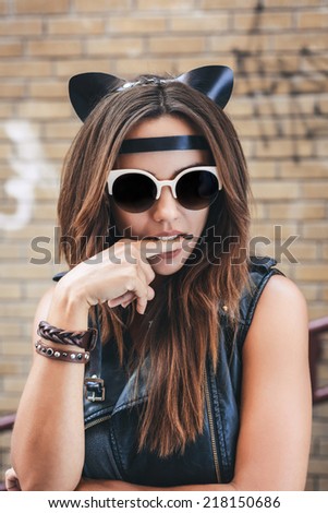 Bad girl with leather cat ears. Urban scene. Outdoor lifestyle portrait