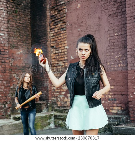 Two Bad girls with Molotov cocktail bomb in the street.  Outdoor lifestyle portrait